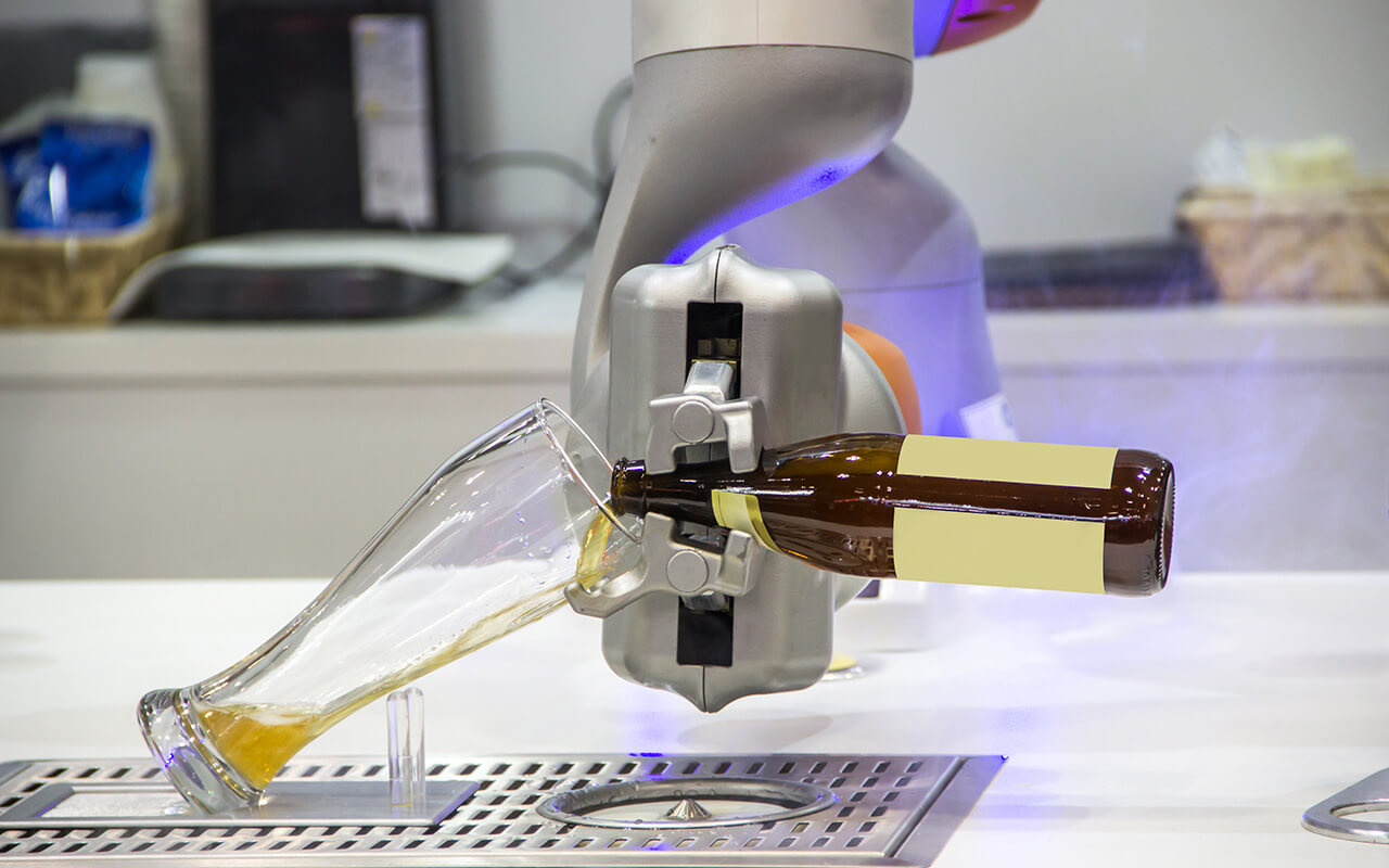 Bartending robot is pouring beer into the glass