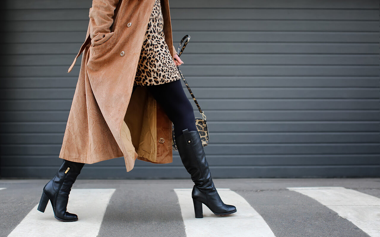 Woman walking down the street in black boots