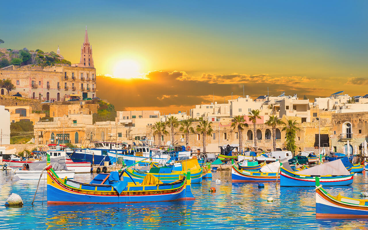 Marsaxlokk bay harbour of Malta, with beautiful architecture and boats at dusk