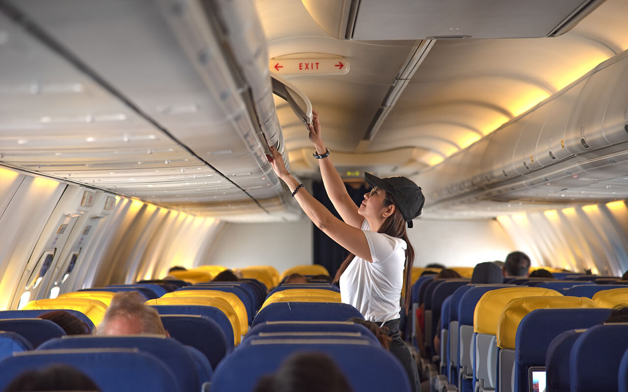 Passenger on a plane retrieving their bags