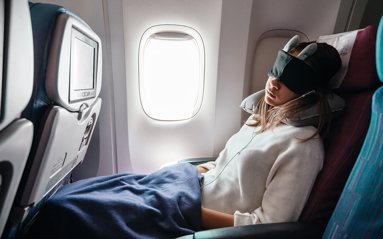 Woman in a sleep mask on an airplane 