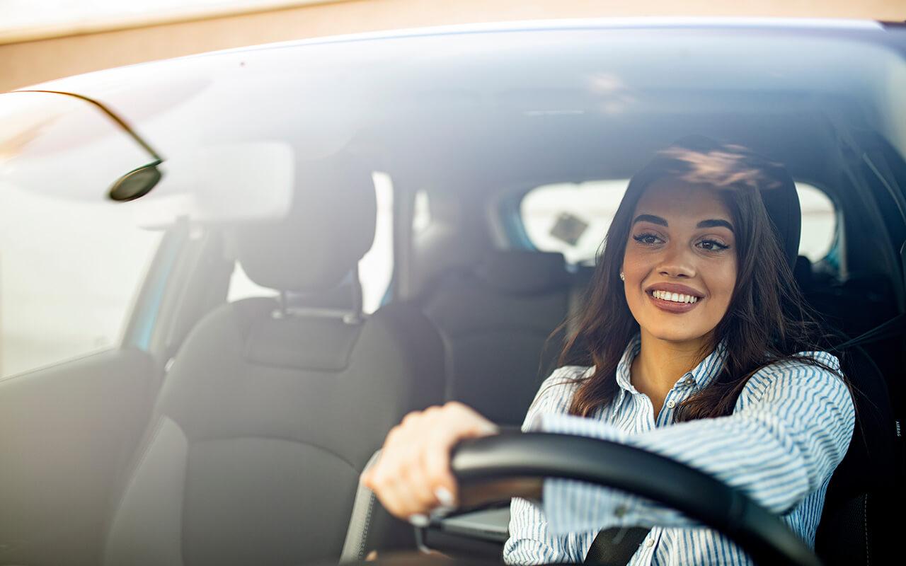 Woman driving a car and smiling