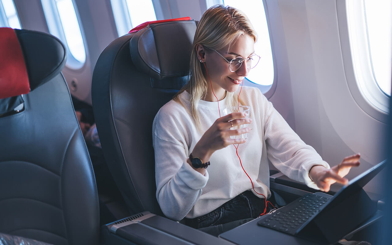 Smiling woman with headphones on a plane