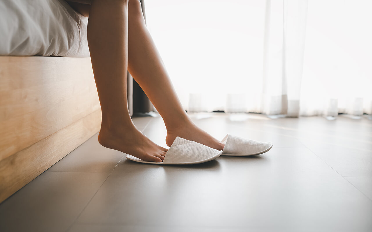 Woman putting on slippers 