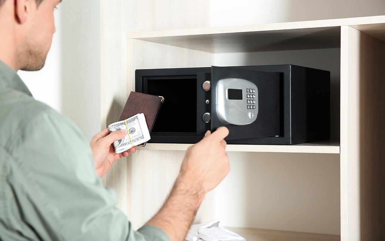 Man putting cash into a hotel safe