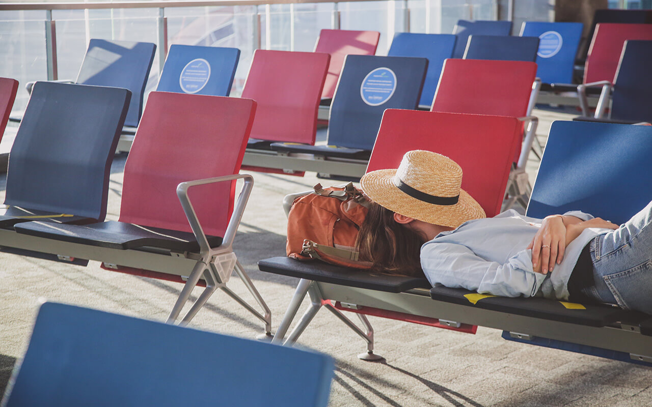 woman taking a nap on a chair, hat covering her face