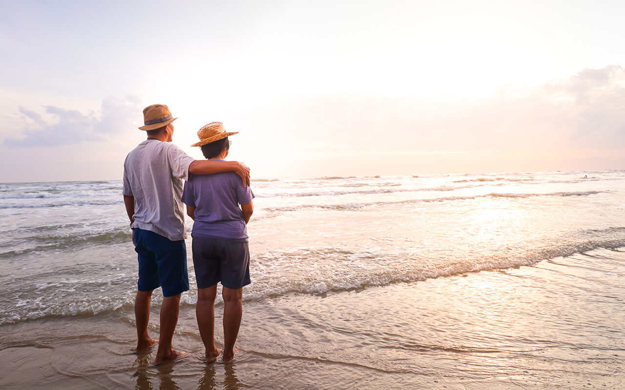 couple Stand together on the beach Look at the beautiful sea in the morning together.