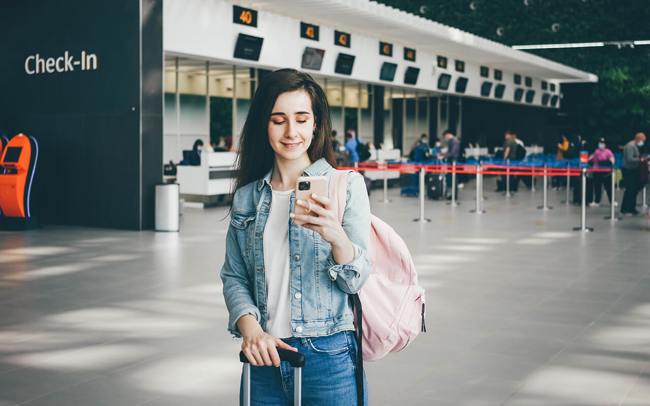 Woman using her phone at an airport