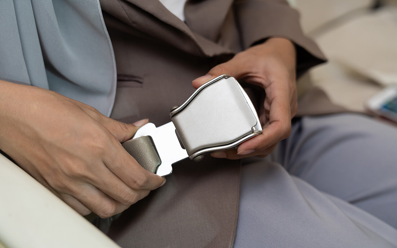 Airplane passenger buckling their seat belt