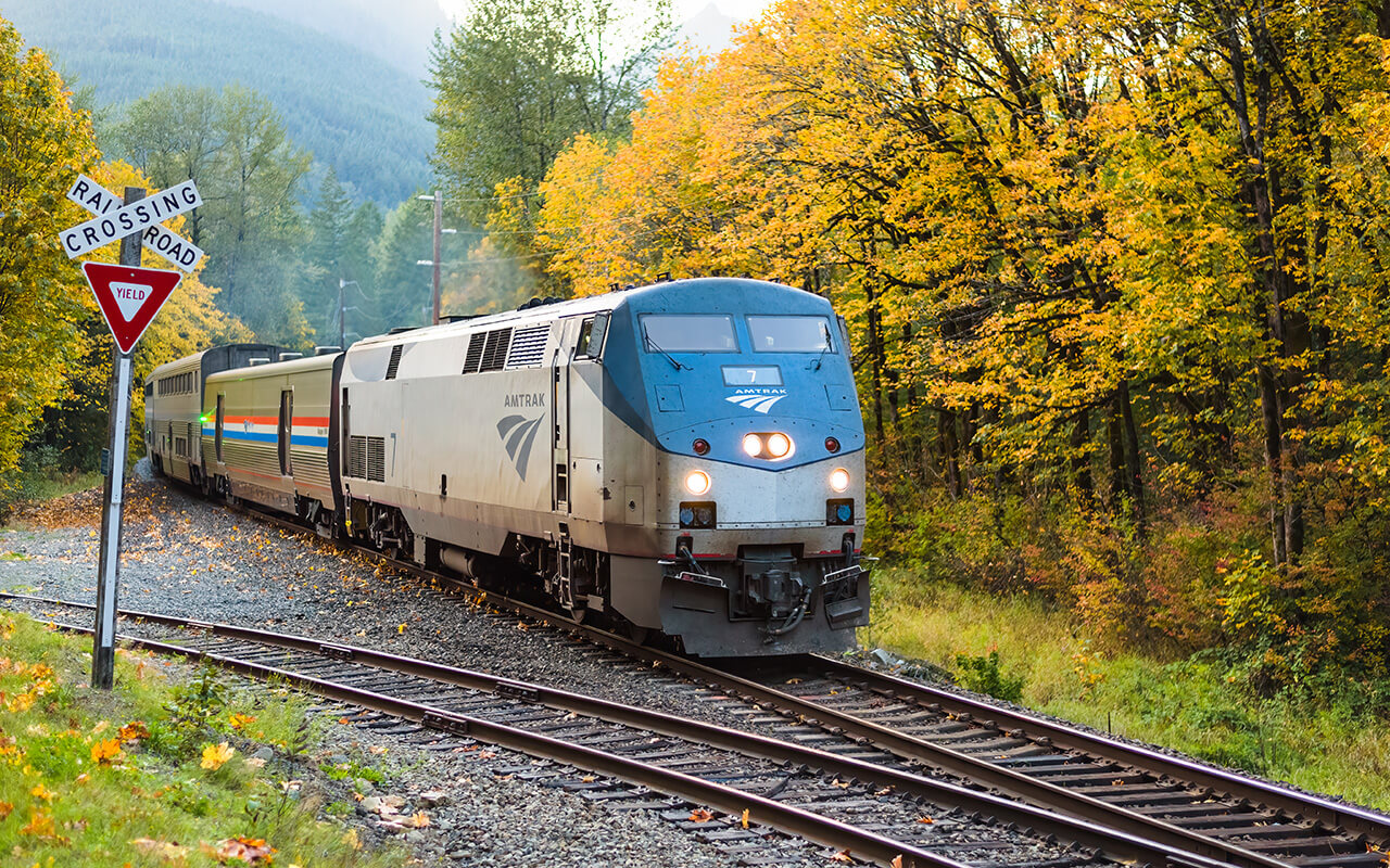 Skykomish, WA, USA - October 01, 2021; An eastbound Amtrak Empire Builder passes through the Cascade Mountains as the trees turn fall colors