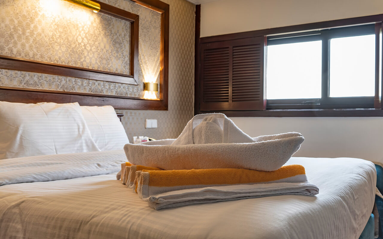 Towel folded into a boat on a cruise ship bed