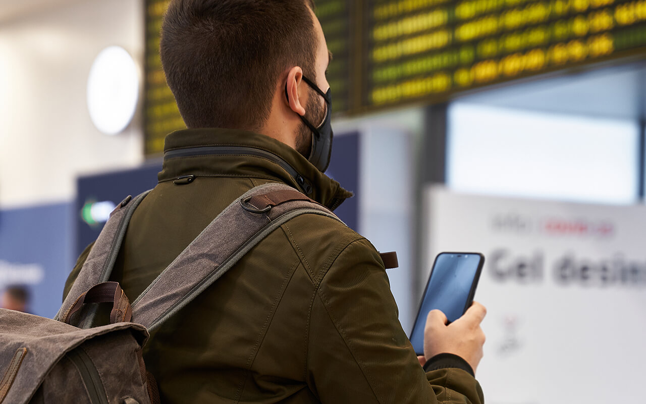 Man using his phone at an airport