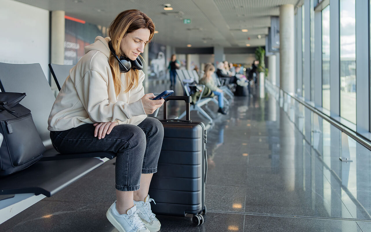 woman looking at her phone at an airport