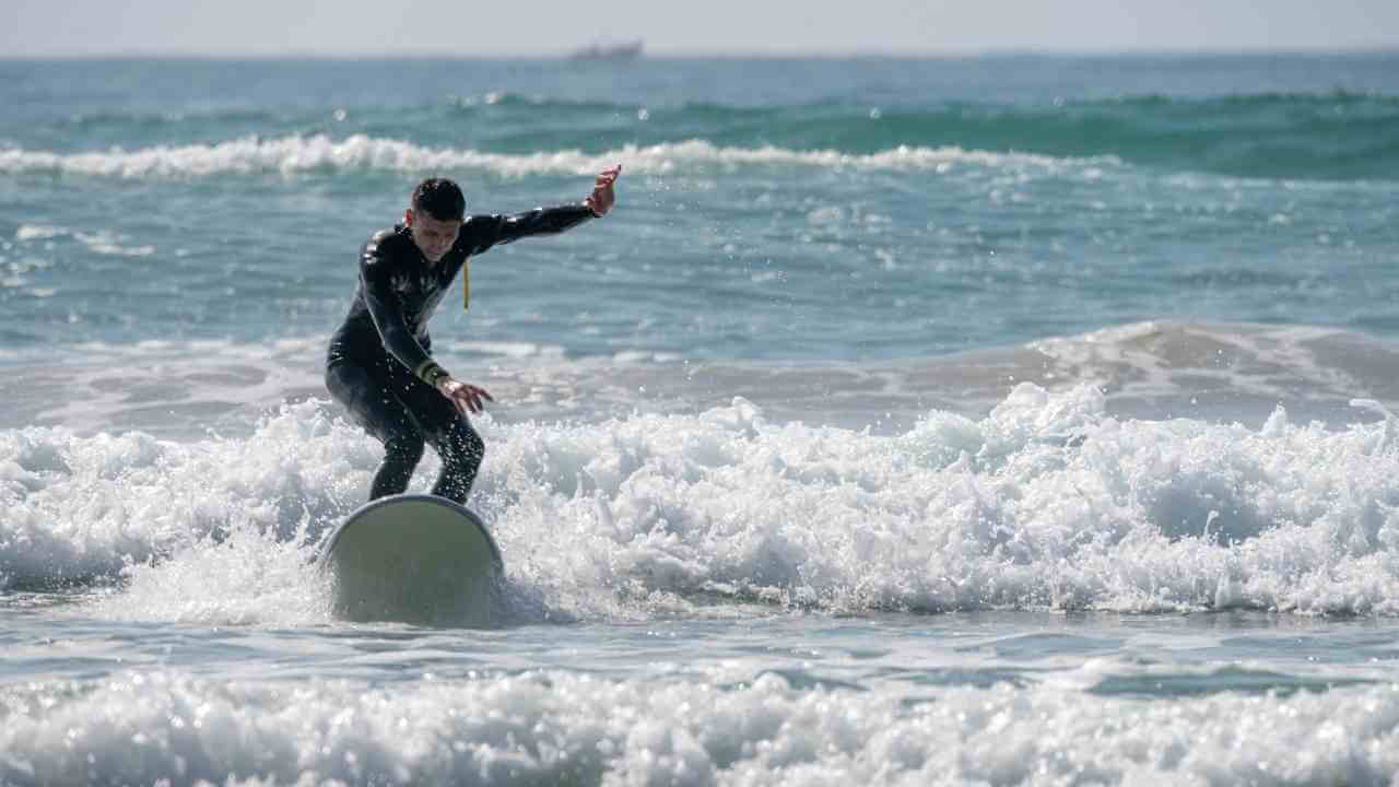 a person in a wetsuit riding a surfboard in the ocean