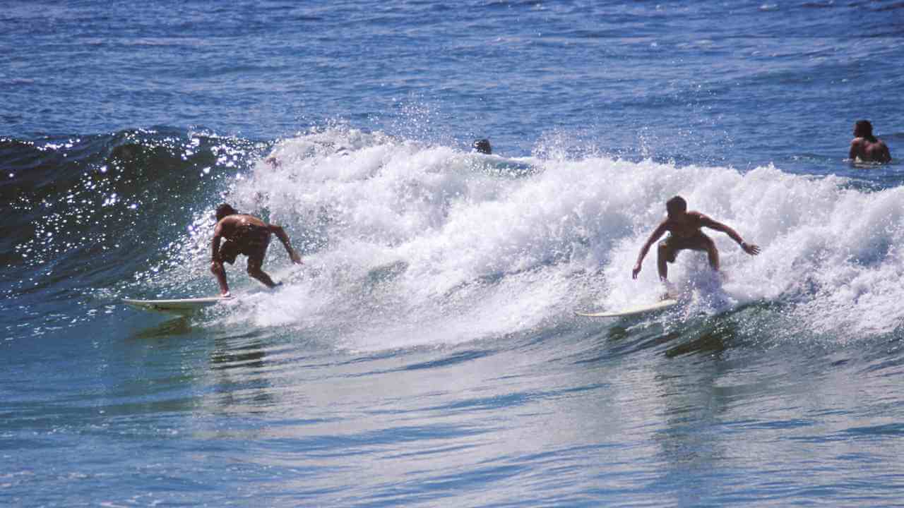 two people on surfboards riding waves in the ocean