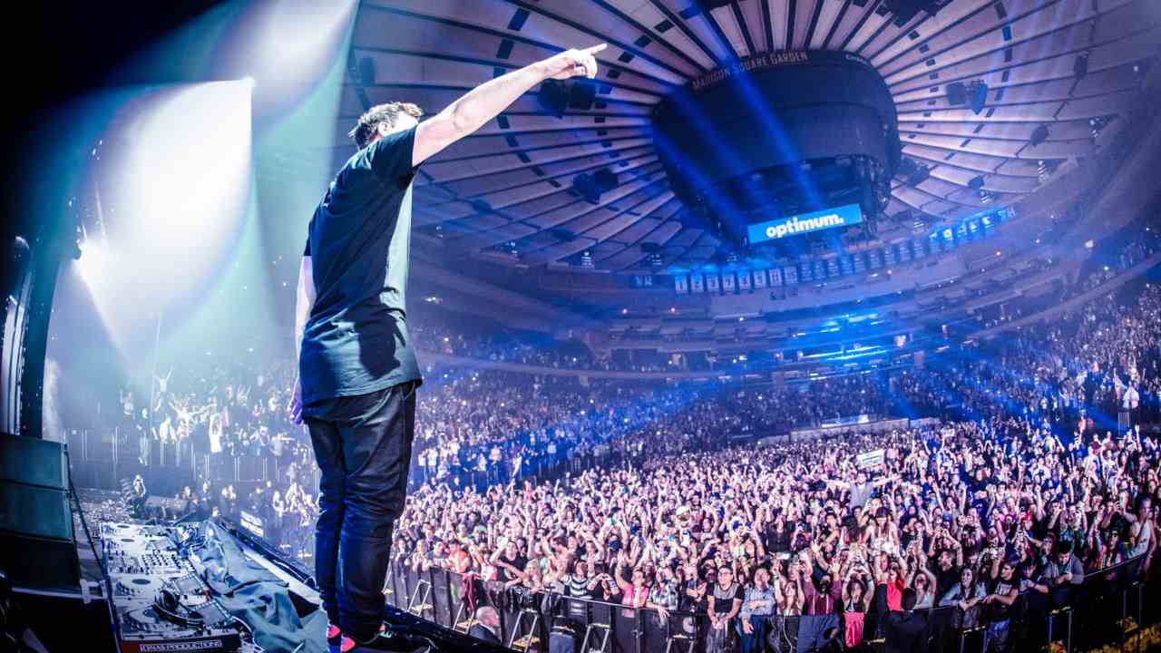 a person standing on a stage in front of a large crowd