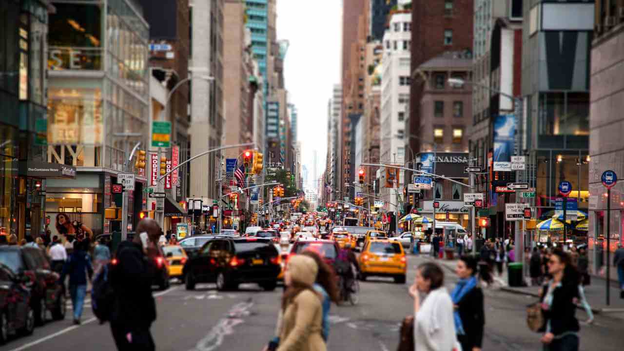 many people are walking down the street in a busy city