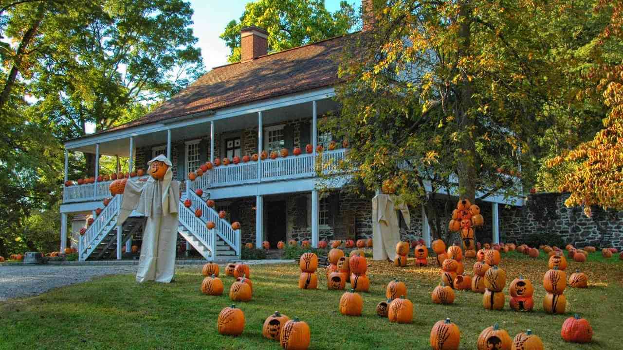 pumpkins and scarecrows in front of a house