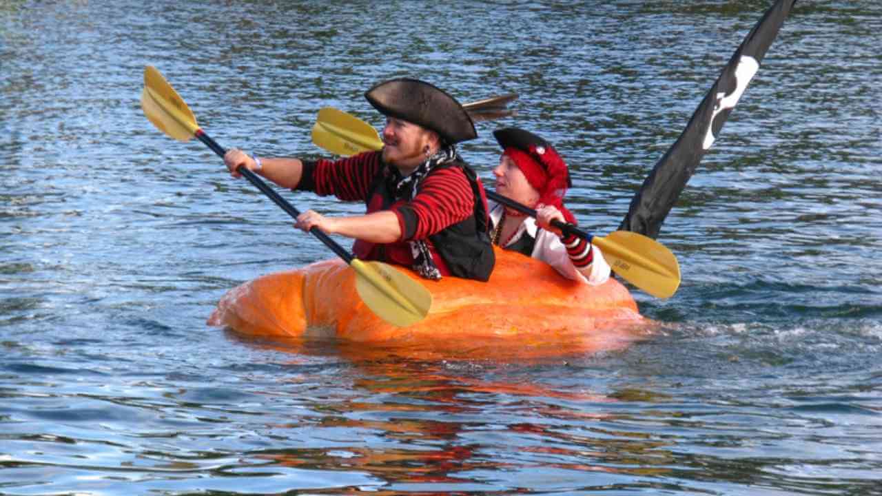 a person in a pirate costume paddles a boat in the water