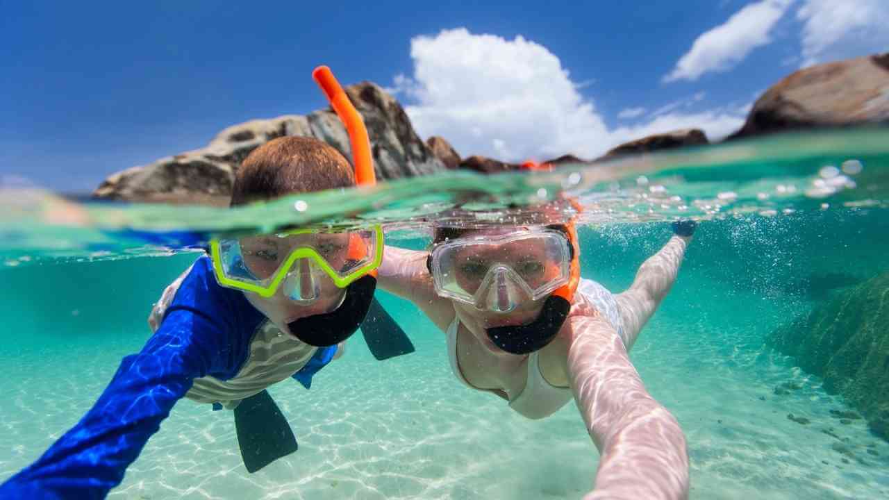 A parent and child snorkeling in the Bahamas.