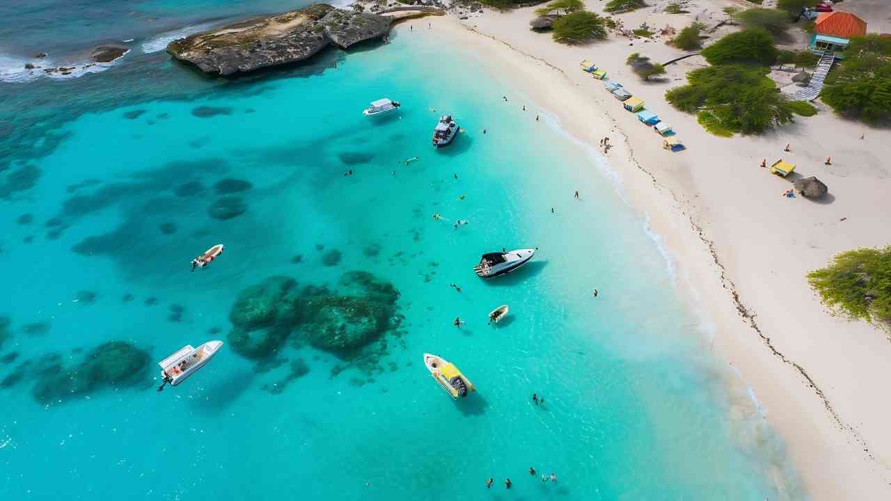 an aerial view of a beach with boats in the water