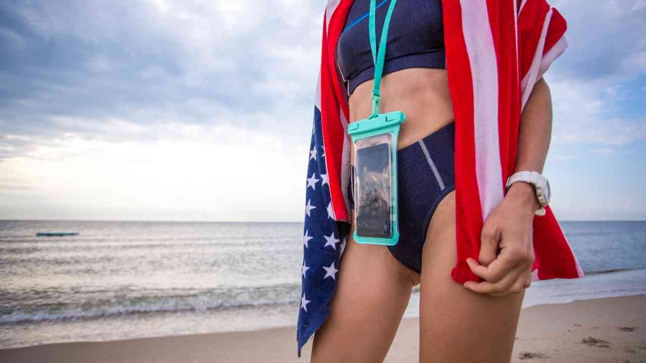 a person with an american flag wrapped around them is standing on the beach