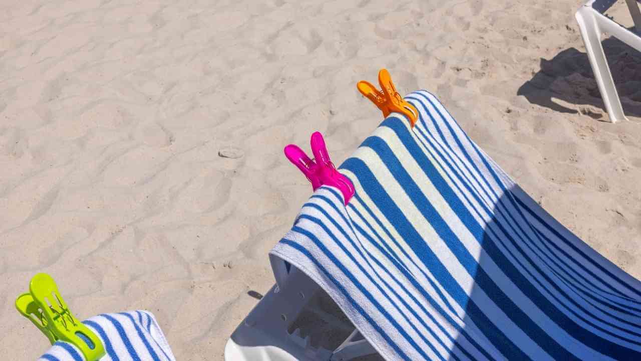 beach towels with colorful clips on them on a sandy beach