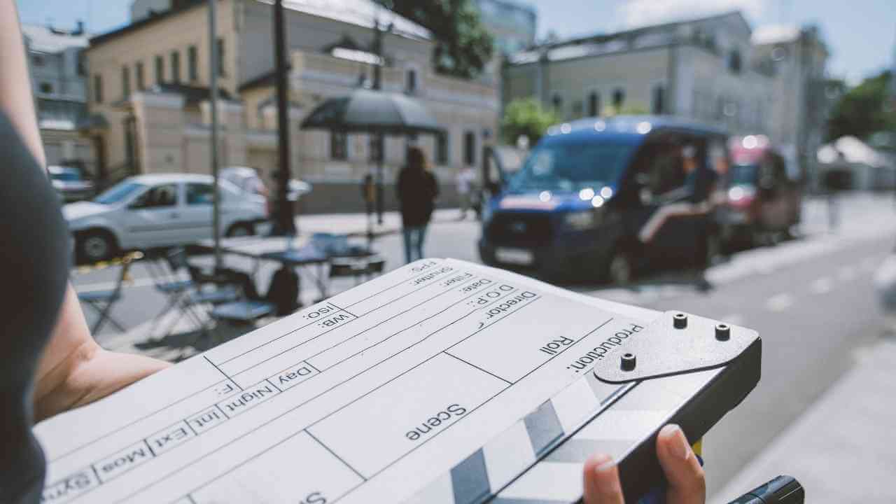 a person holding a clapper board on the street