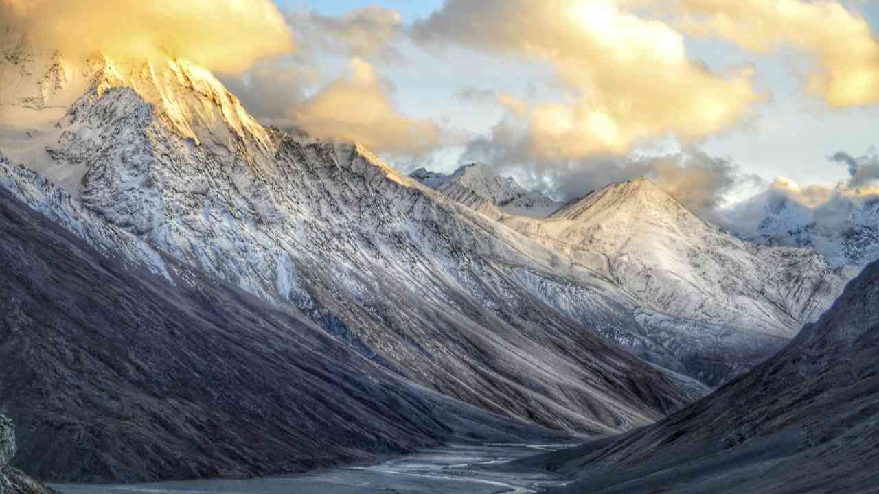 the mountains are covered with snow and clouds