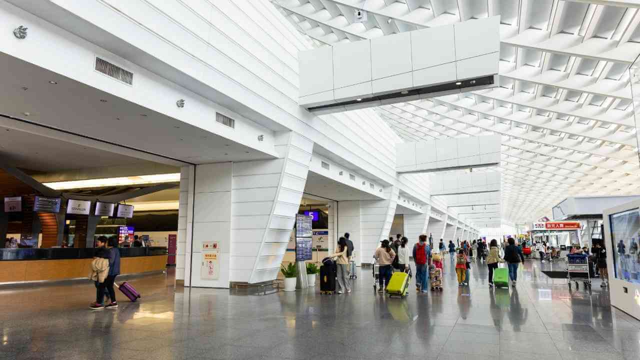 people walking through an airport terminal with luggage