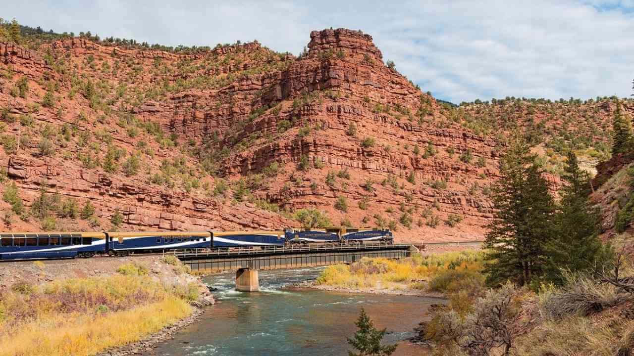 a train traveling over a bridge in the mountains