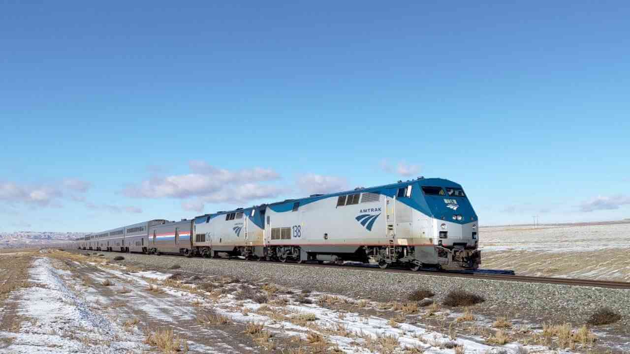 an amtrak train traveling through a snowy landscape