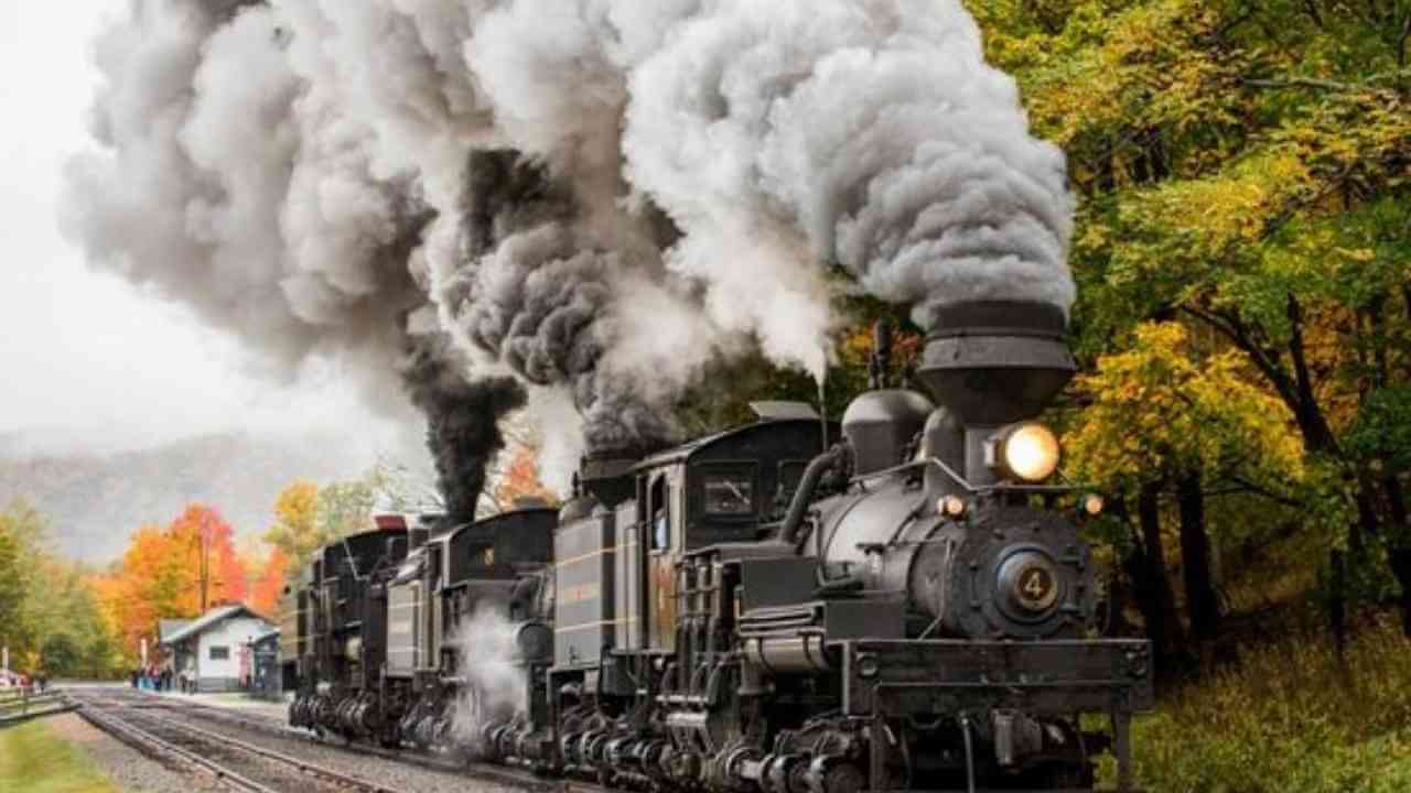 a steam train traveling down the tracks with smoke coming out of it