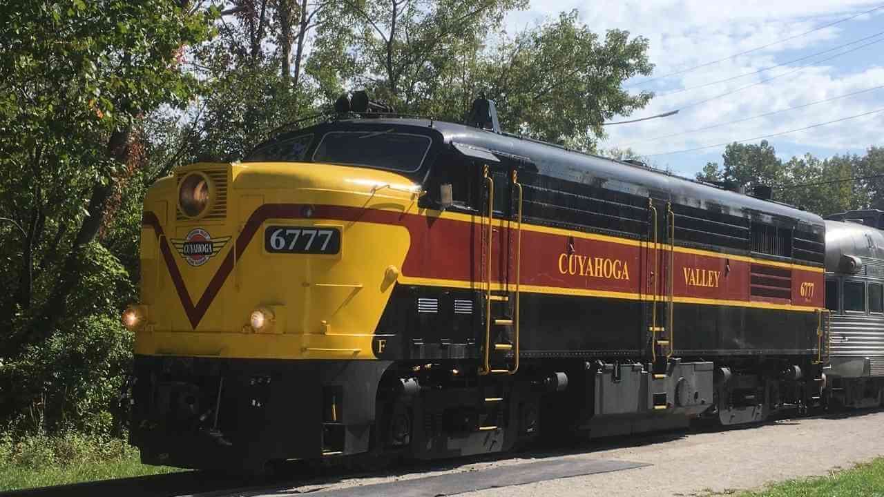 a yellow and black train traveling down the tracks