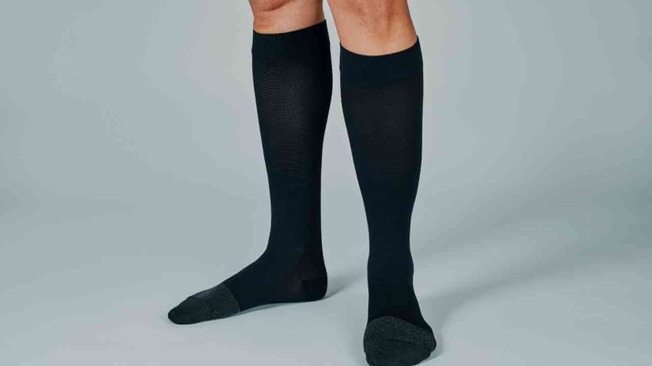 the legs of a person wearing black knee high socks