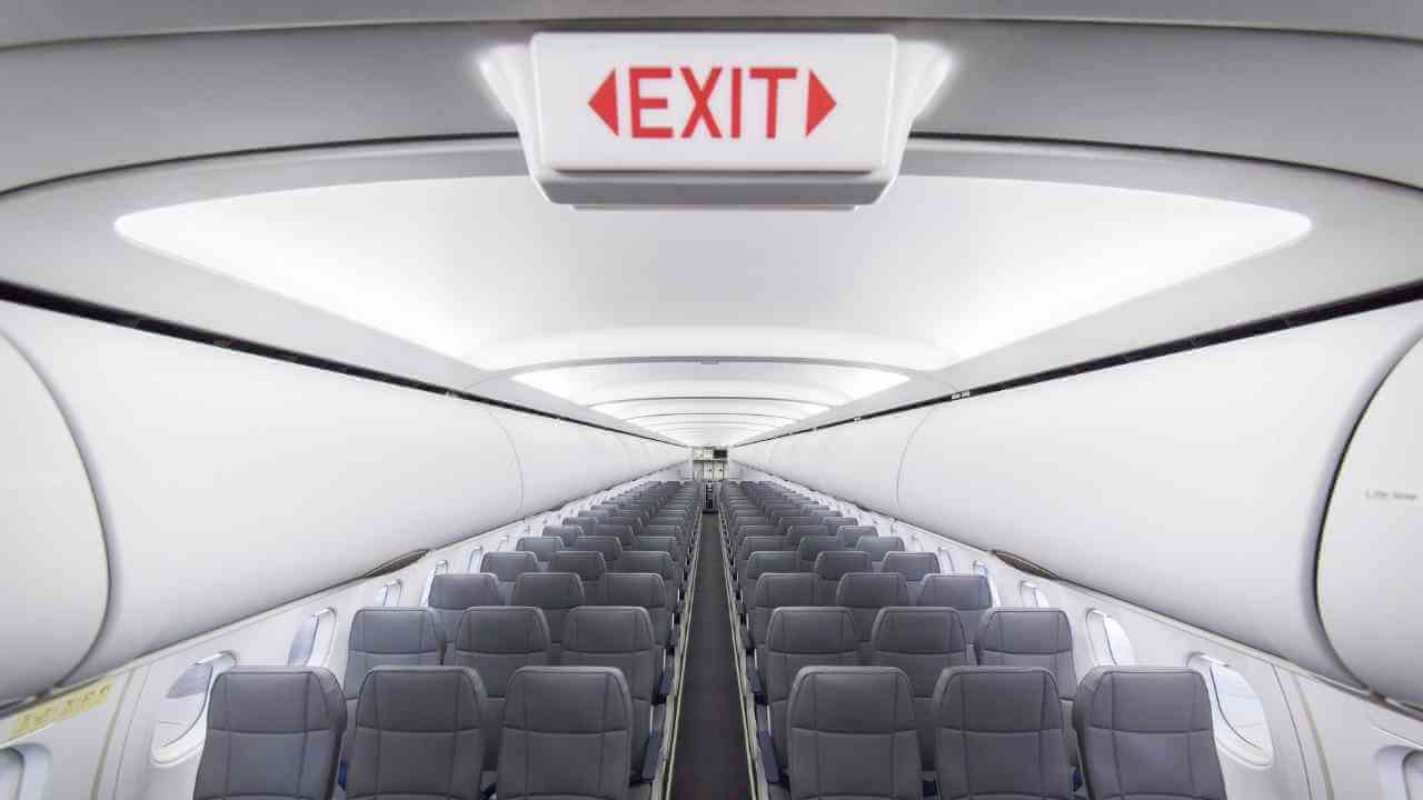 an airplane with empty seats and an exit sign