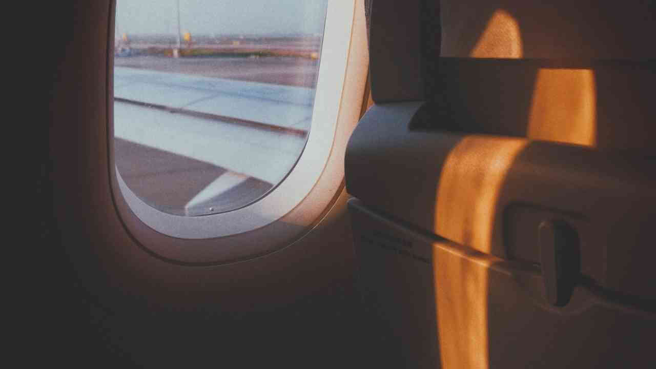 an airplane window with the sun shining through it