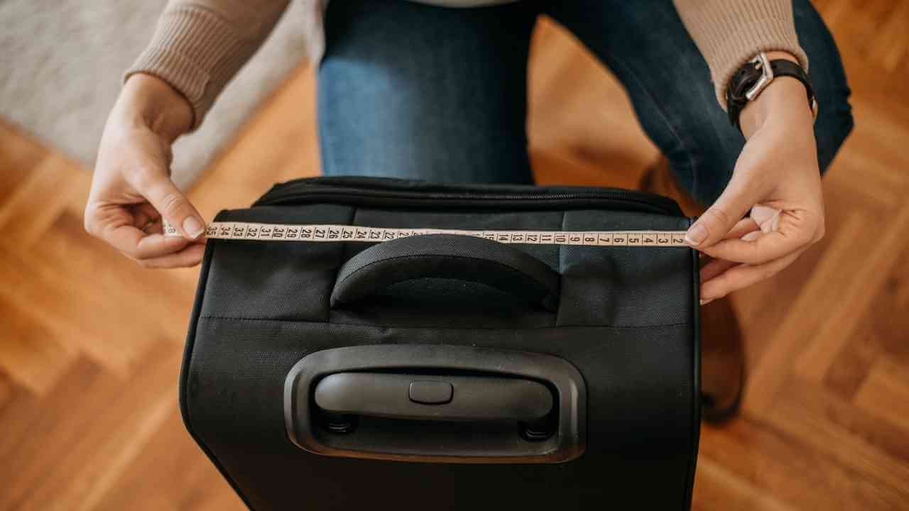 a person is measuring the size of a suitcase