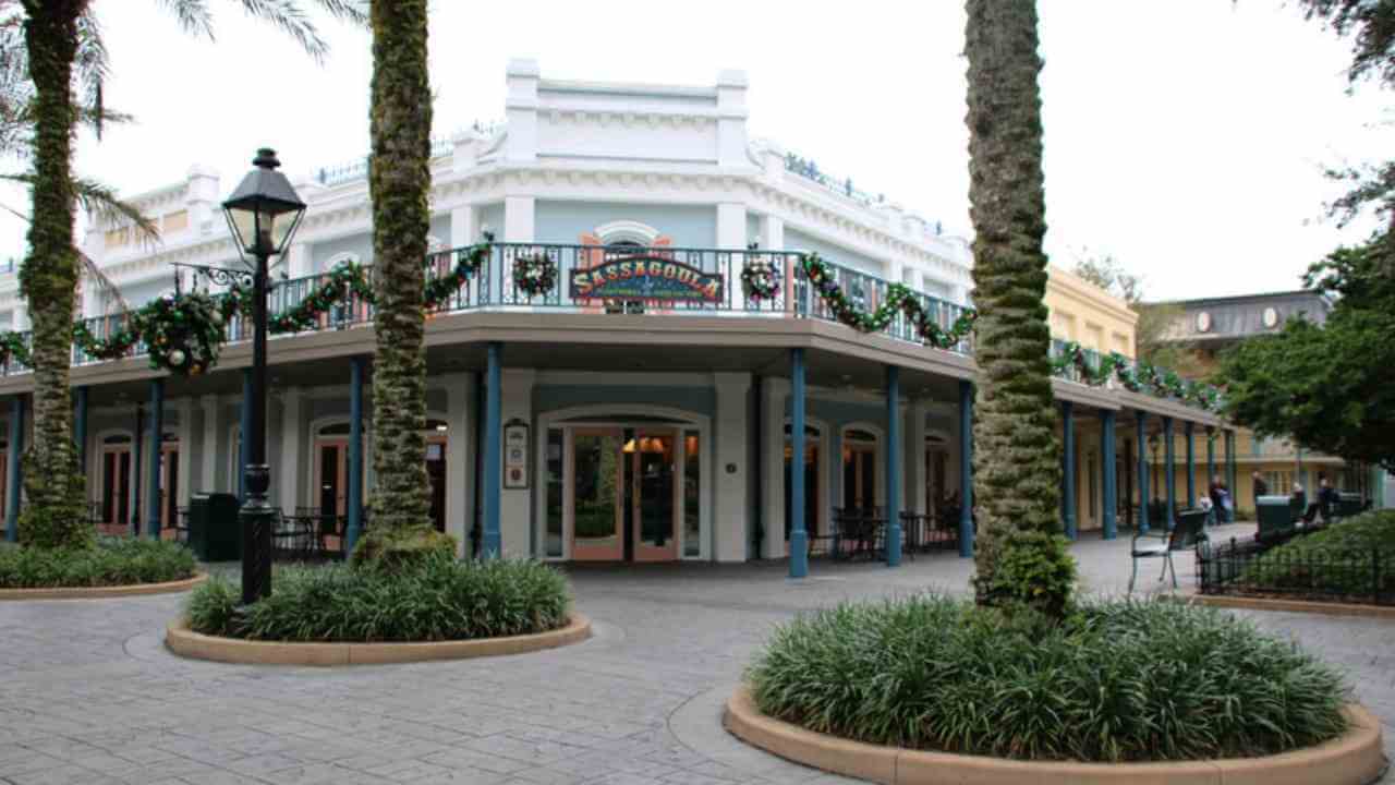 the front of a building with palm trees in front of it