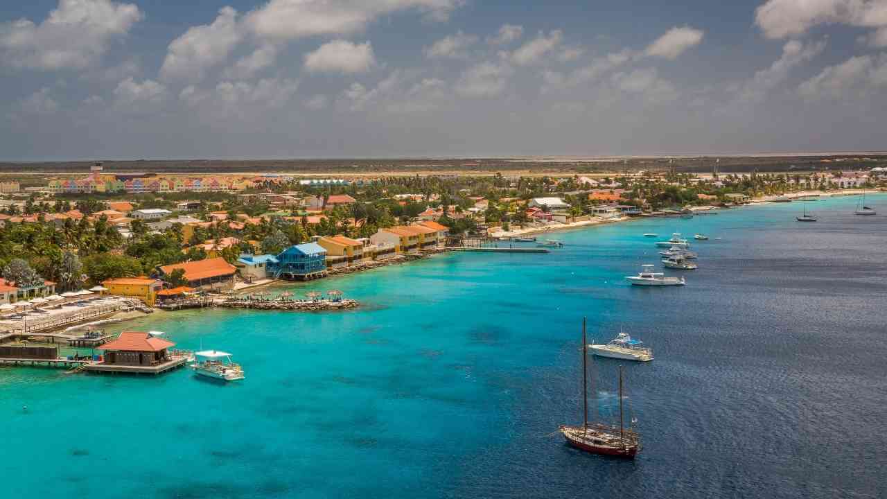 an aerial view of a tropical island with boats in the water