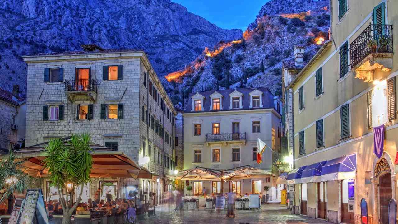 an image of a city street at night with mountains in the background