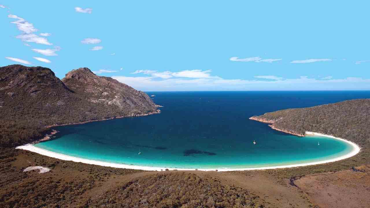 an aerial view of a beach in the middle of a large body of water