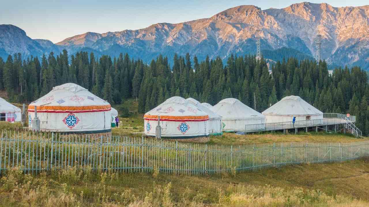 several yurts in the mountains with mountains in the background