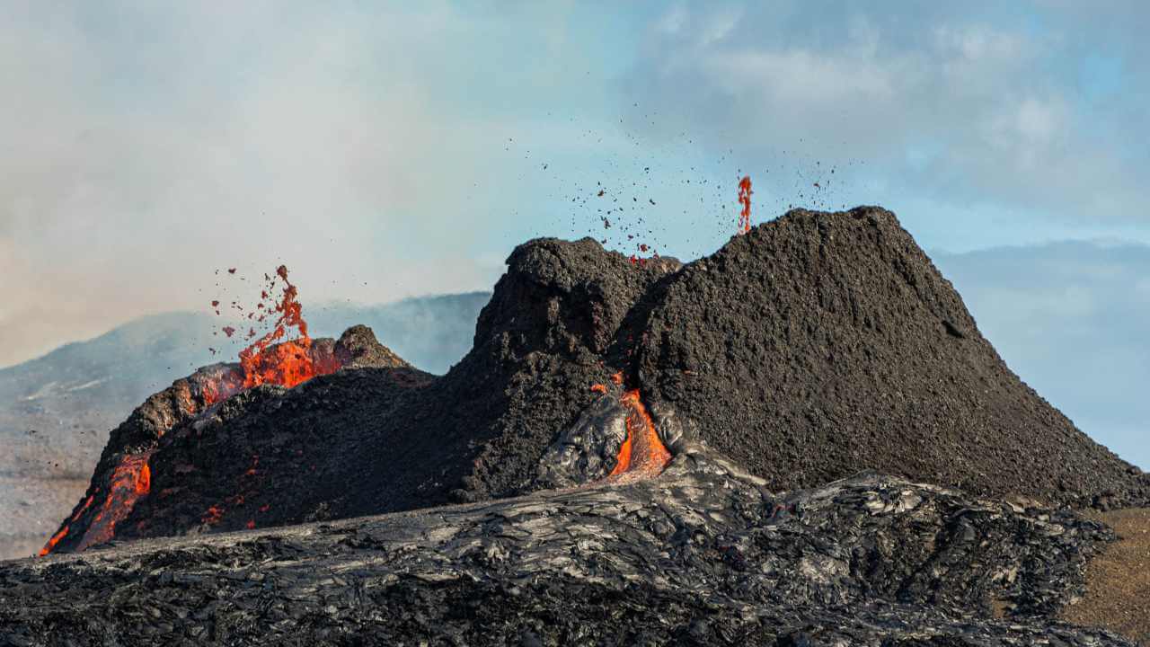 an image of a volcano with lava flowing out of it