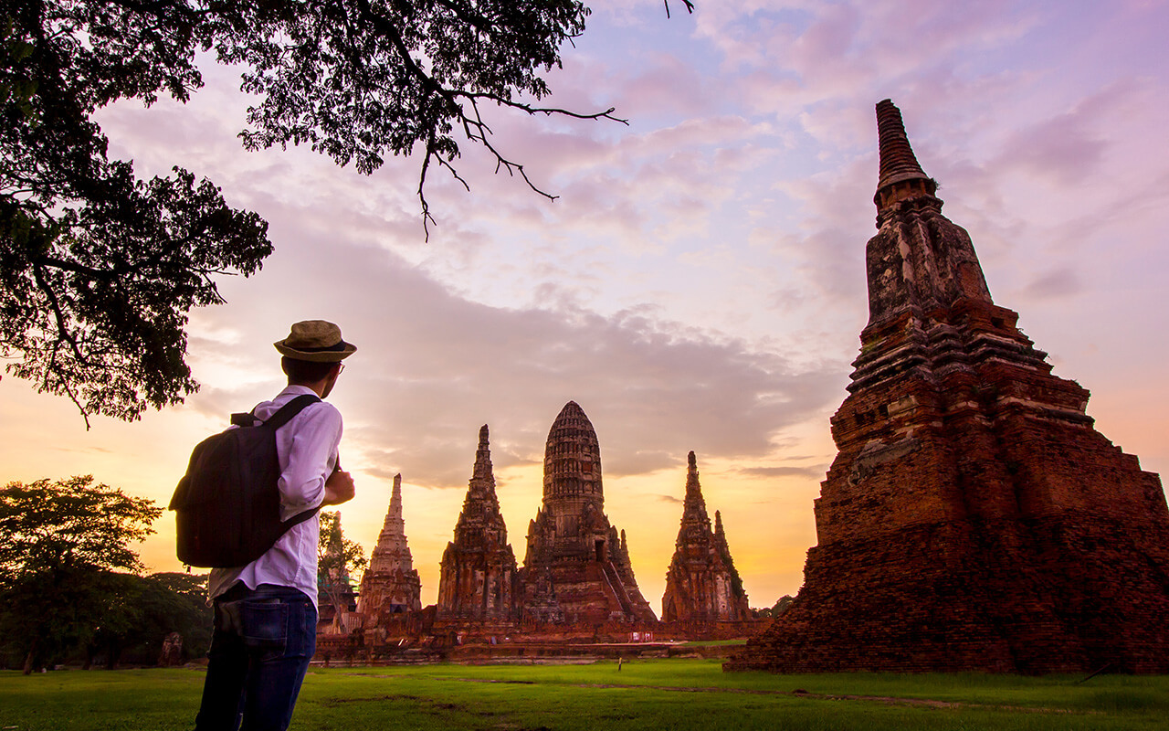 Young man travel in Ayutthaya Historical Park at Wat Chaiwatthanaram where UNESCO World Heritage Site