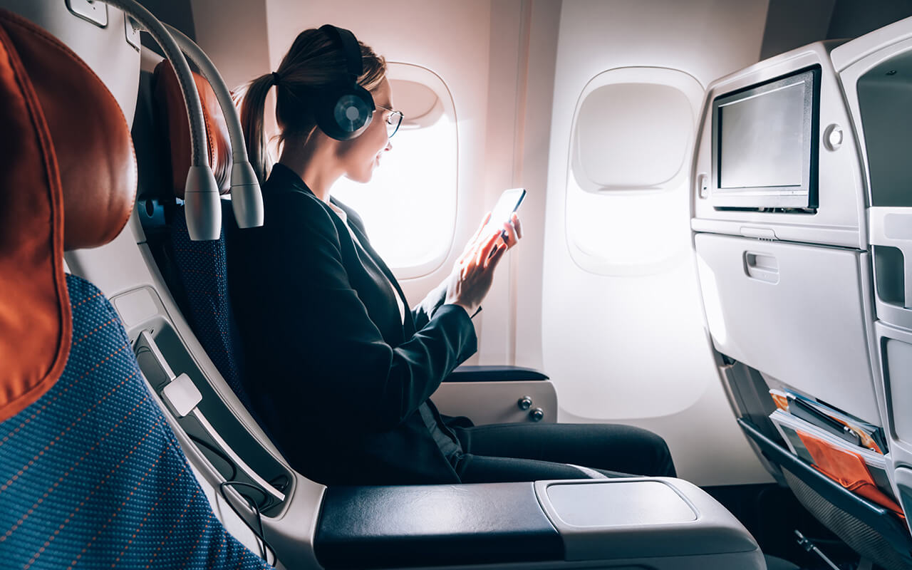 Woman looking at phone on airplane