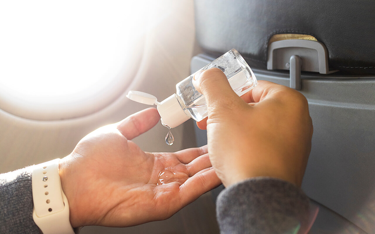 Applying hand sanitizer on an airplane