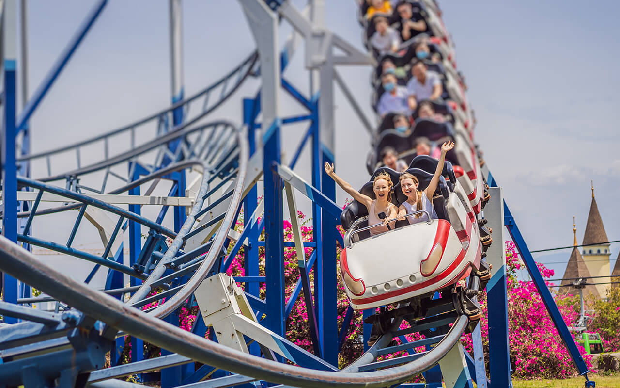 Happy friends in amusement park on a summer day