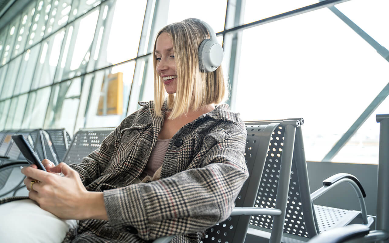 Woman wearing headphones at airport 