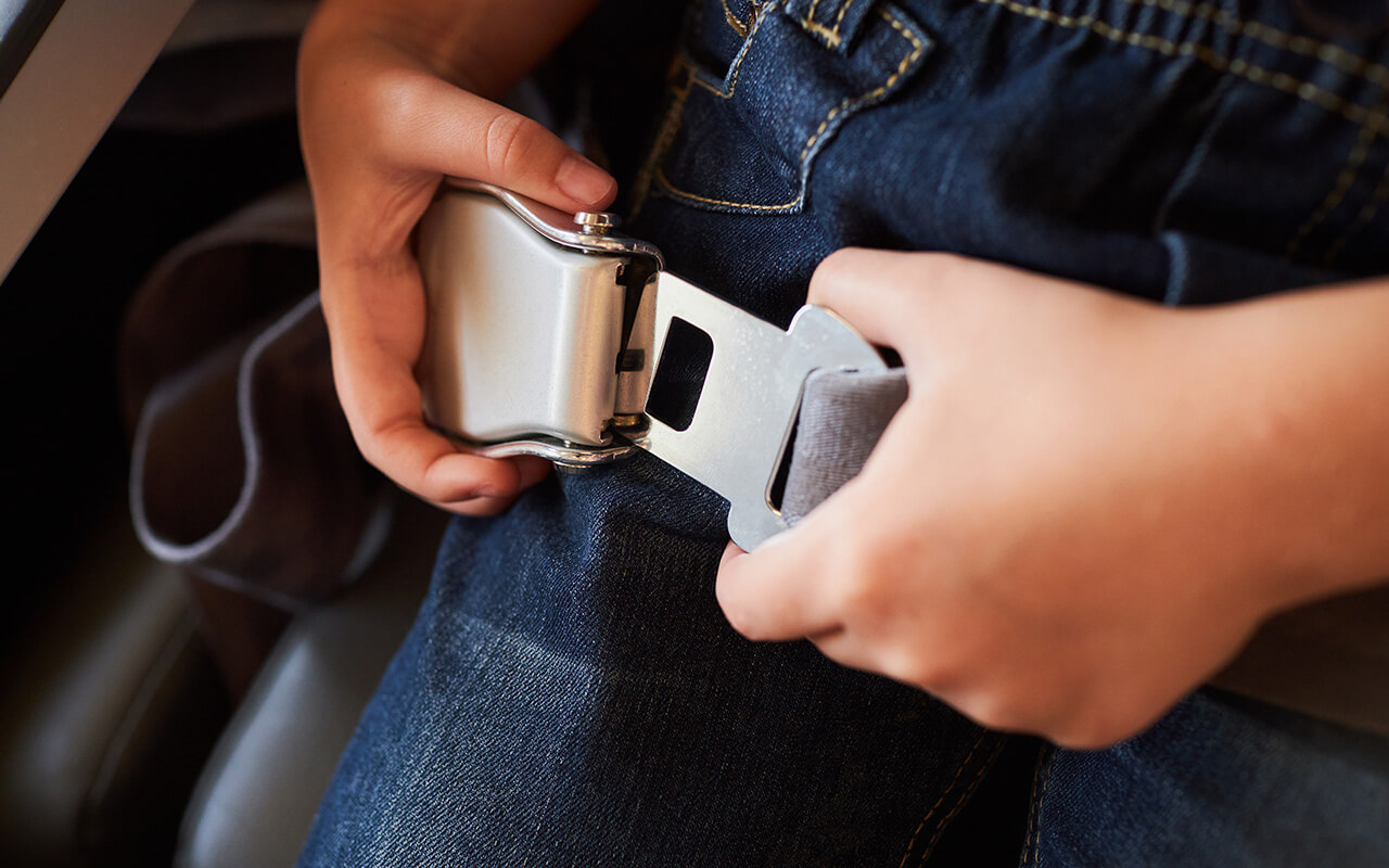 Person putting on airplane seatbelt